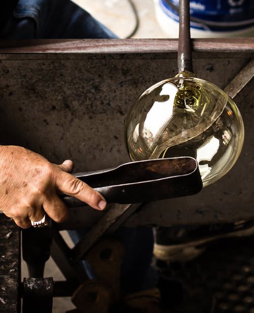 Un artisan façonnant une pièce de verre soufflé